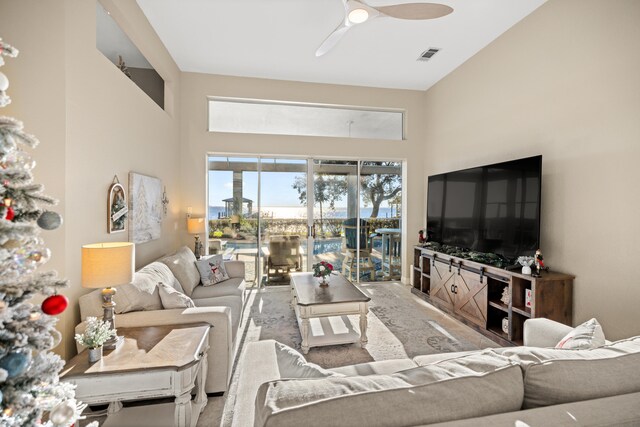 living room with a towering ceiling and ceiling fan