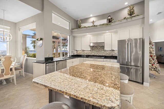 kitchen featuring pendant lighting, a kitchen island, white cabinets, and stainless steel appliances