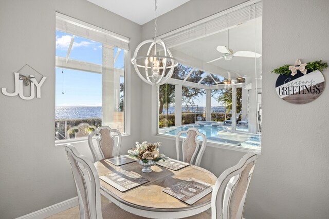 tiled dining room with a water view and a notable chandelier