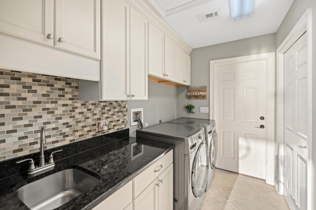 washroom featuring washer and clothes dryer, light tile patterned flooring, cabinets, and sink