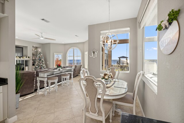 dining room featuring light tile patterned floors and ceiling fan with notable chandelier