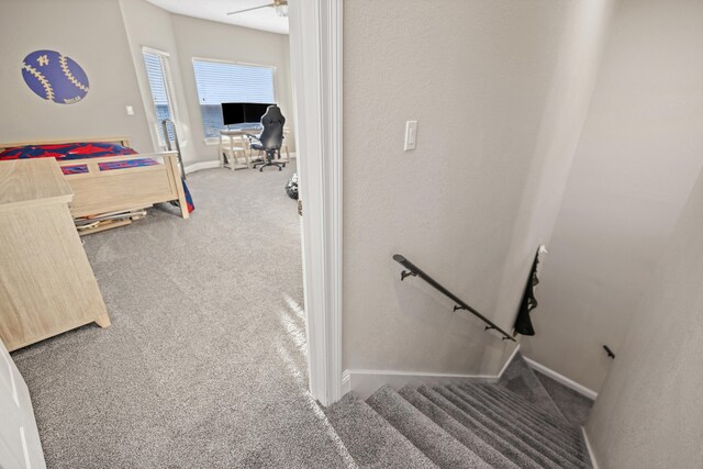 staircase with carpet floors and ceiling fan