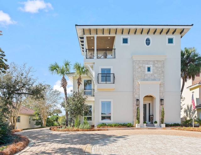 125 Emerald Rdg, Santa Rosa Beach, FL 32459 - view of front facade featuring stone siding, stucco siding, and a balcony