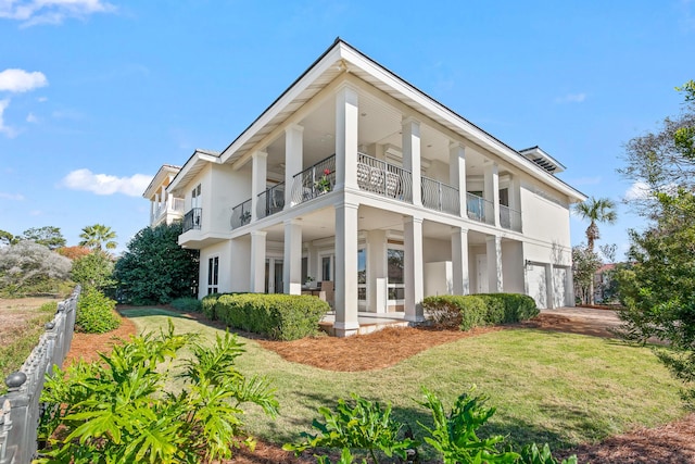 rear view of house with a balcony and a lawn