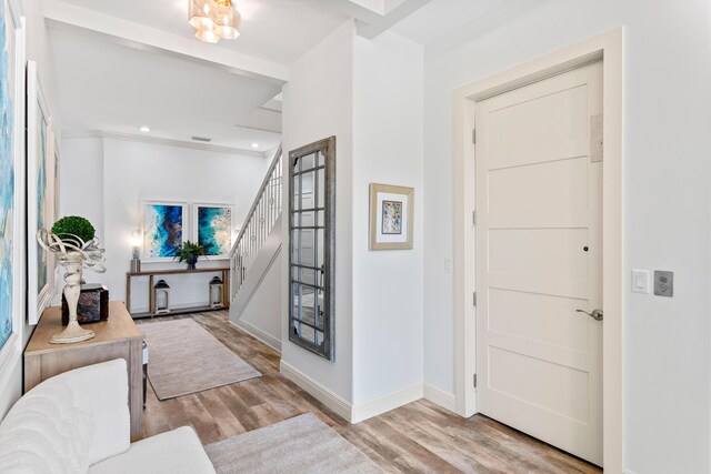 entryway with light hardwood / wood-style flooring and a notable chandelier