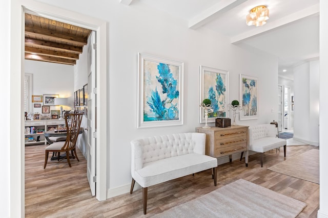 living area featuring beam ceiling and light hardwood / wood-style floors