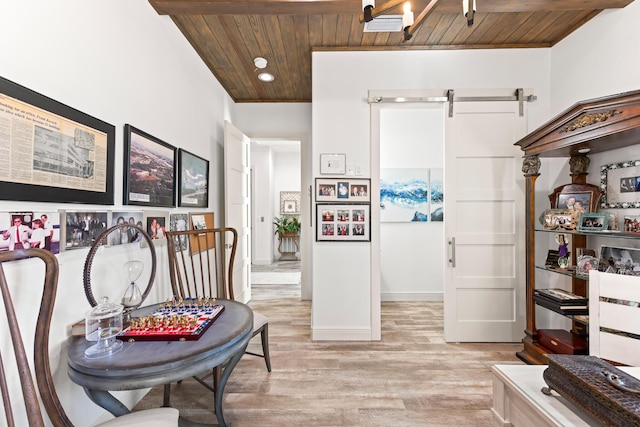 interior space featuring a barn door, wood ceiling, and light wood-type flooring