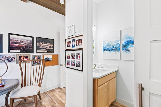 bathroom with vanity, wood-type flooring, and lofted ceiling