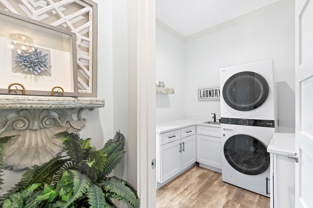 washroom with cabinets, sink, crown molding, light hardwood / wood-style flooring, and stacked washer / dryer