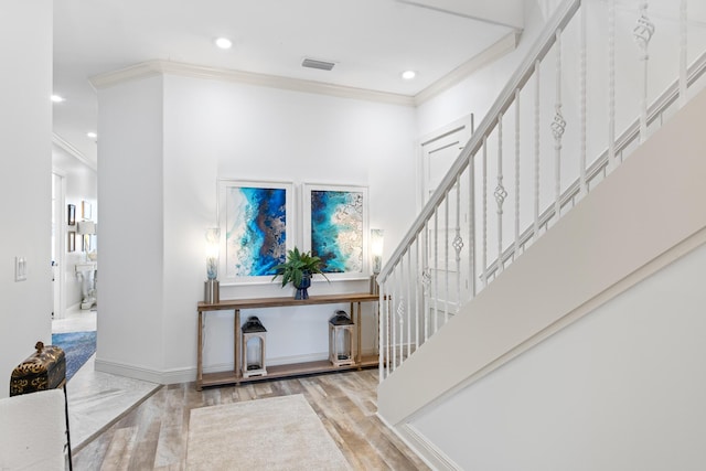 foyer entrance featuring light hardwood / wood-style floors and ornamental molding