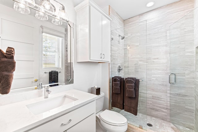 bathroom with vanity, an enclosed shower, and toilet