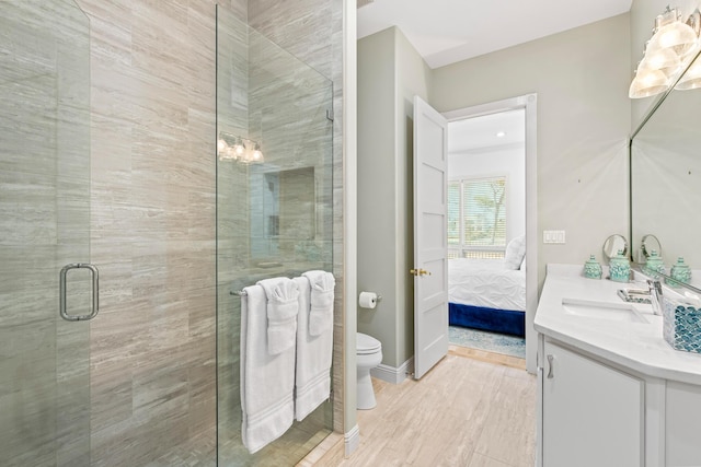 bathroom with hardwood / wood-style flooring, vanity, toilet, and walk in shower