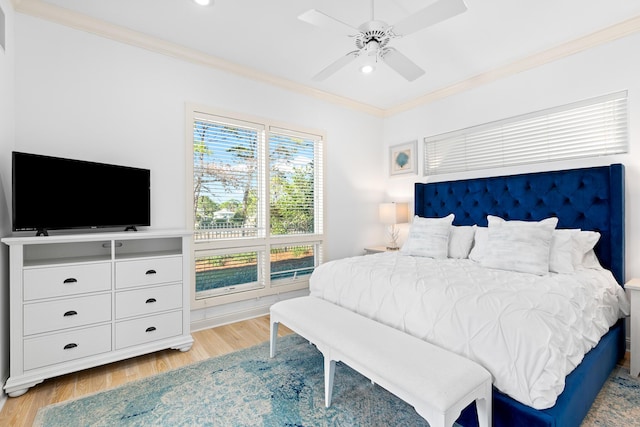 bedroom featuring ceiling fan, light hardwood / wood-style floors, and crown molding