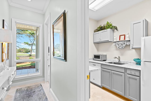 kitchen with gray cabinetry, sink, light stone counters, white appliances, and ornamental molding