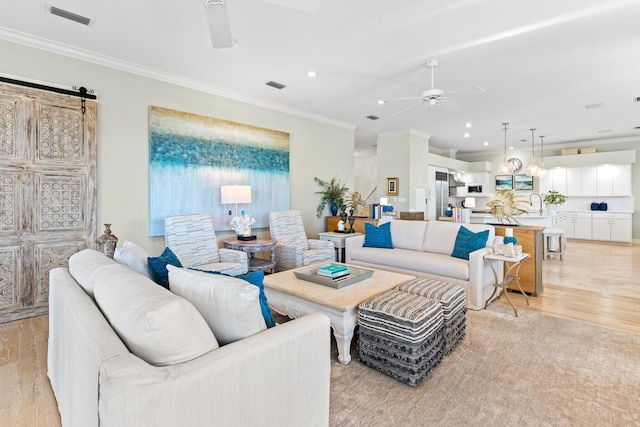 living room featuring ceiling fan, light hardwood / wood-style floors, and ornamental molding