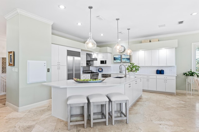 kitchen with white cabinetry, sink, wall chimney exhaust hood, built in appliances, and a spacious island