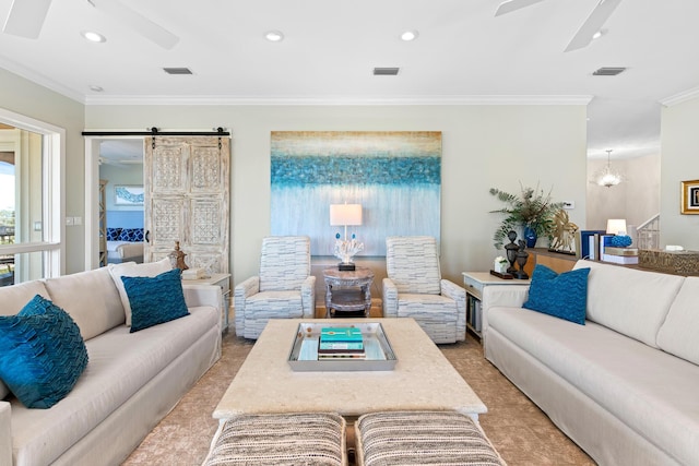 carpeted living room featuring ceiling fan with notable chandelier, a barn door, and crown molding