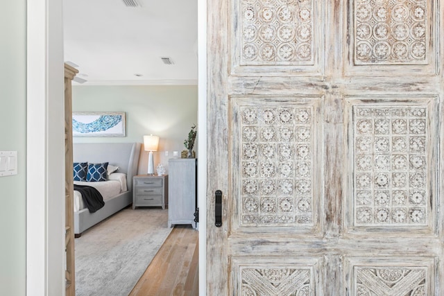 bedroom with light hardwood / wood-style floors and crown molding