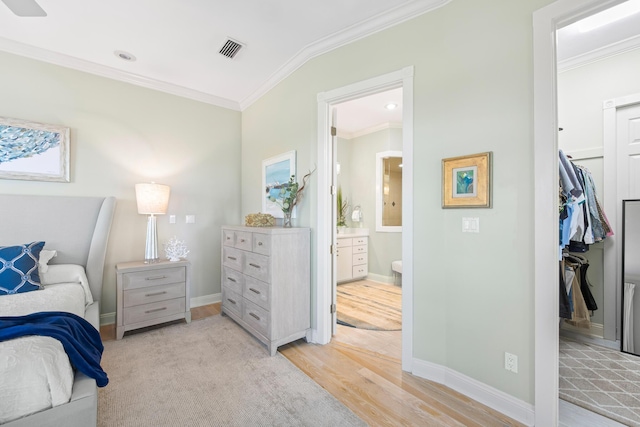 bedroom with ensuite bath, crown molding, a closet, and light hardwood / wood-style flooring