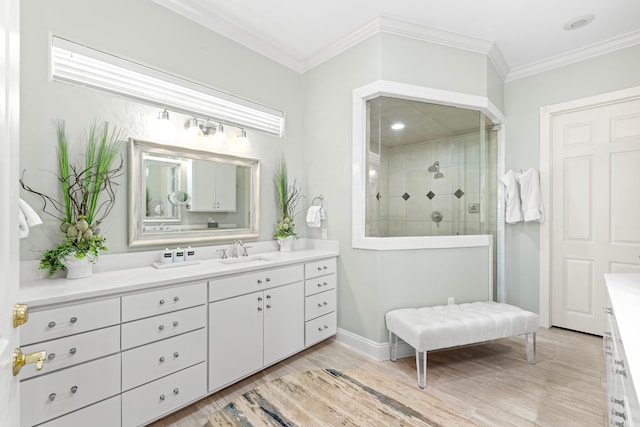 bathroom featuring a tile shower, vanity, ornamental molding, and hardwood / wood-style flooring