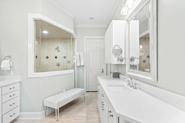 bathroom with vanity, a tile shower, ornamental molding, and wood-type flooring