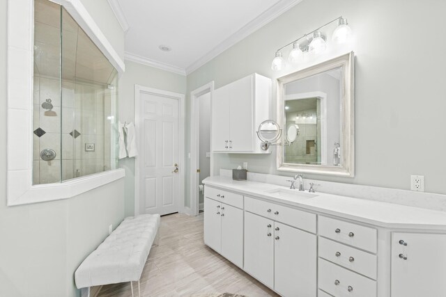 bathroom with vanity, a shower with door, and crown molding