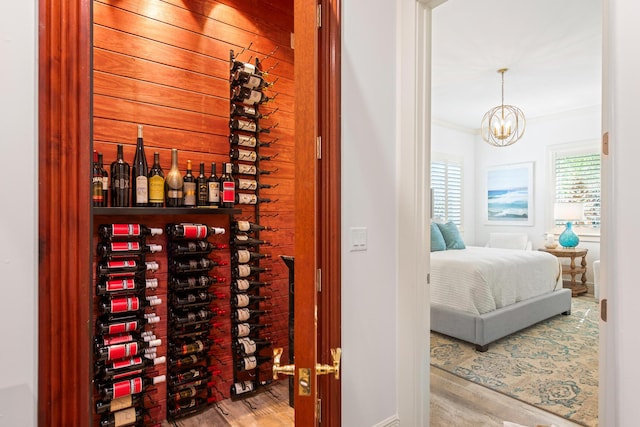 wine cellar featuring light wood-type flooring and a notable chandelier