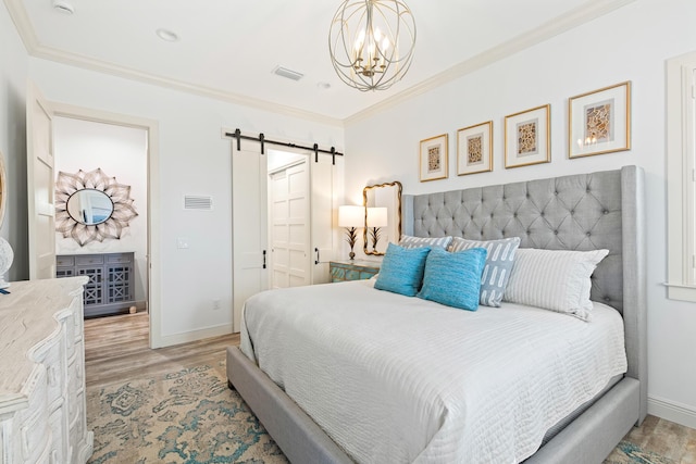 bedroom featuring a barn door, light hardwood / wood-style flooring, an inviting chandelier, and ornamental molding