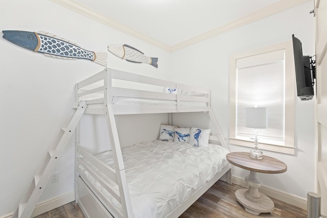 bedroom featuring crown molding and dark wood-type flooring