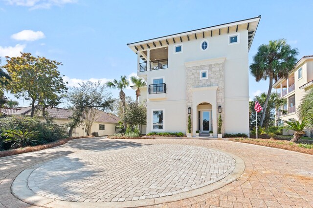 125 Emerald Rdg, Santa Rosa Beach, FL 32459 - view of front of home featuring stucco siding, stone siding, curved driveway, and a balcony