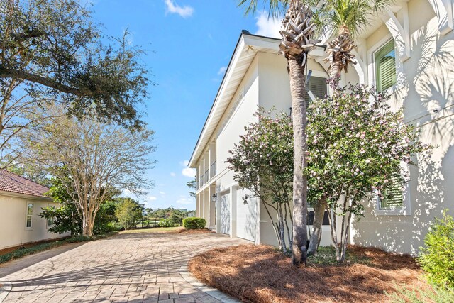125 Emerald Rdg, Santa Rosa Beach, FL 32459 - view of property exterior featuring a garage, decorative driveway, and stucco siding