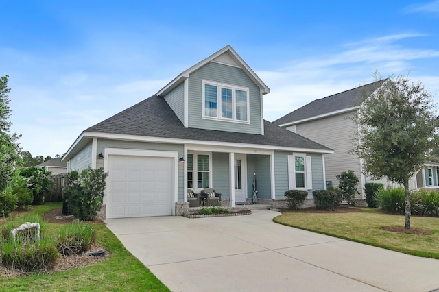 view of front of home with covered porch, a front yard, and a garage