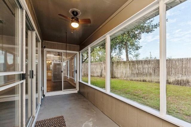 unfurnished sunroom with ceiling fan