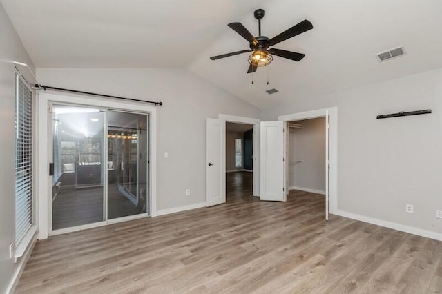 empty room with light hardwood / wood-style floors, ceiling fan, and lofted ceiling