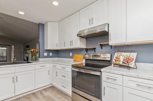 kitchen with electric stove, light hardwood / wood-style flooring, white cabinets, and sink