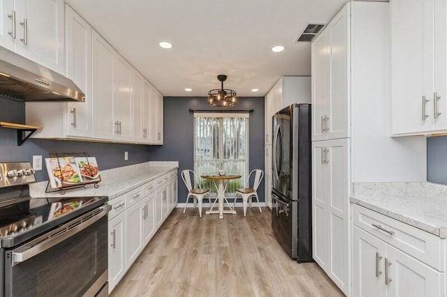 kitchen with white cabinetry, stainless steel appliances, light stone counters, and light wood-type flooring