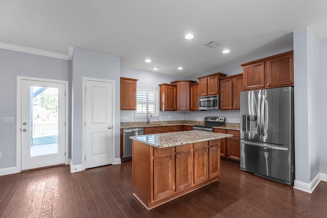 kitchen featuring a wealth of natural light, a kitchen island, dark wood-type flooring, and appliances with stainless steel finishes