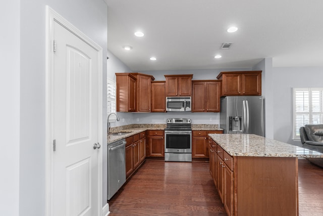 kitchen featuring light stone countertops, sink, dark hardwood / wood-style floors, and appliances with stainless steel finishes