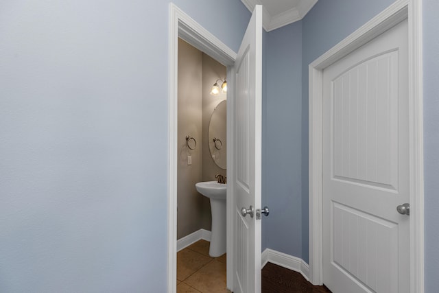 bathroom with crown molding and tile patterned flooring