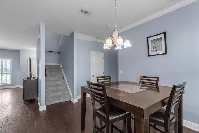 dining space with dark hardwood / wood-style floors, an inviting chandelier, and ornamental molding