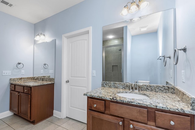 bathroom with toilet, vanity, tile patterned floors, and walk in shower