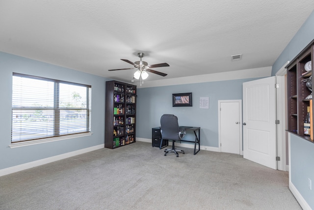 carpeted office with ceiling fan and a textured ceiling