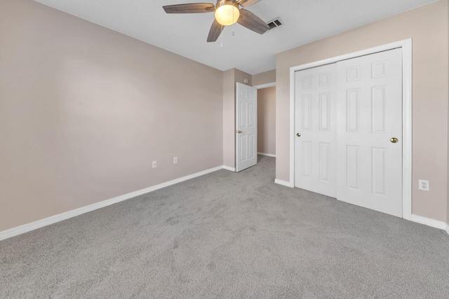 unfurnished bedroom featuring a closet, light colored carpet, and ceiling fan