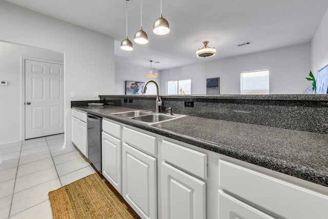 kitchen featuring stainless steel dishwasher, sink, pendant lighting, white cabinets, and light tile patterned flooring