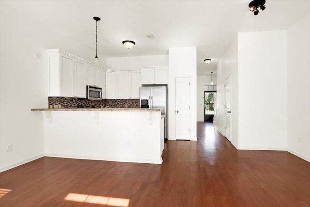 kitchen featuring white cabinetry, decorative backsplash, stainless steel appliances, and kitchen peninsula