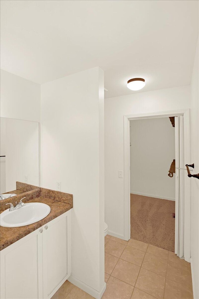 bathroom with tile patterned flooring, vanity, and toilet