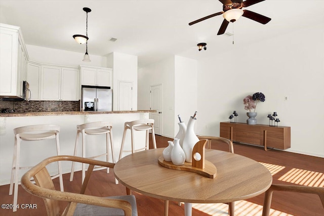 dining space with dark hardwood / wood-style floors and ceiling fan