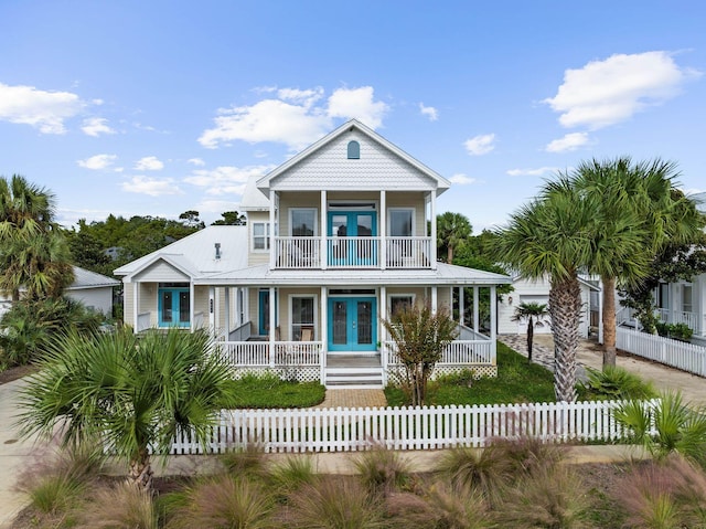 coastal inspired home featuring a balcony and french doors