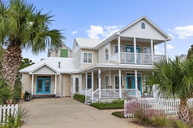 coastal home featuring a balcony and french doors