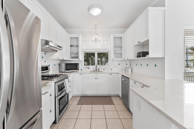 kitchen with a wealth of natural light, white cabinets, pendant lighting, and appliances with stainless steel finishes